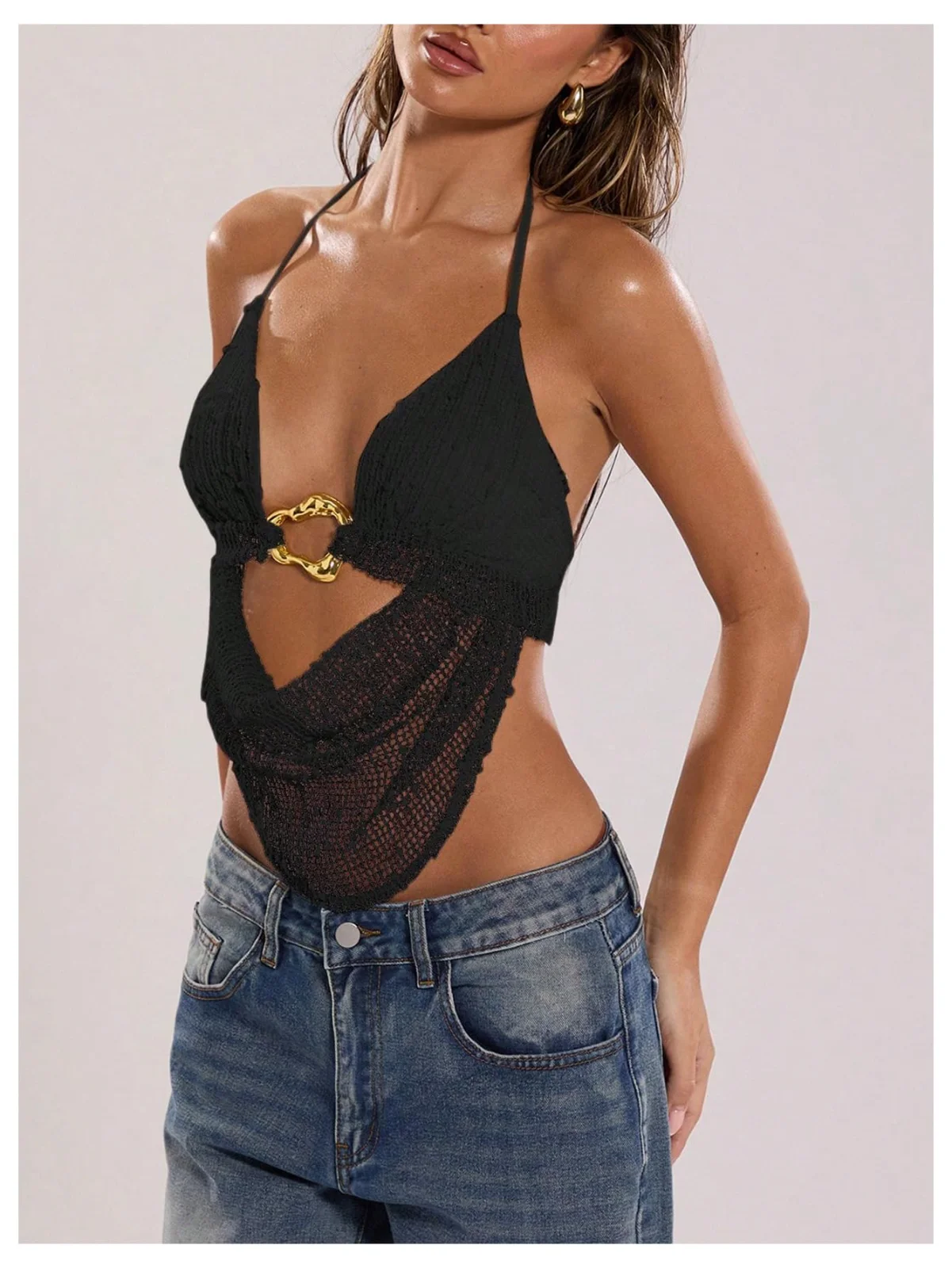 The crochet open-back halter top in black with a metal ring at the front, worn with jeans